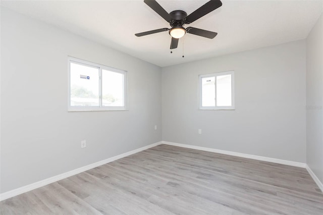 spare room featuring ceiling fan, a wealth of natural light, and light hardwood / wood-style floors