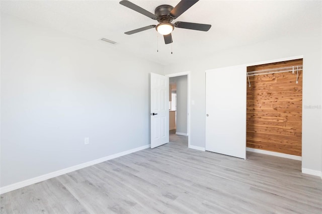 unfurnished bedroom featuring a textured ceiling, ceiling fan, a closet, and light wood-type flooring