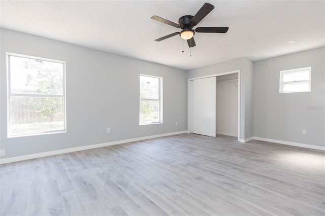 unfurnished bedroom featuring multiple windows, a textured ceiling, ceiling fan, and light hardwood / wood-style floors