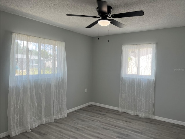 spare room featuring a textured ceiling, hardwood / wood-style flooring, and ceiling fan