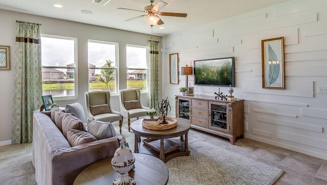 living room with ceiling fan, light tile patterned floors, and plenty of natural light