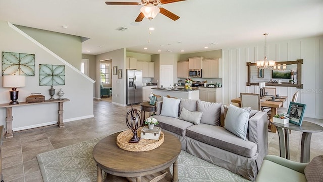 living room featuring ceiling fan with notable chandelier and light tile patterned floors