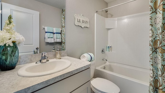 full bathroom with toilet, shower / bathtub combination with curtain, and vanity