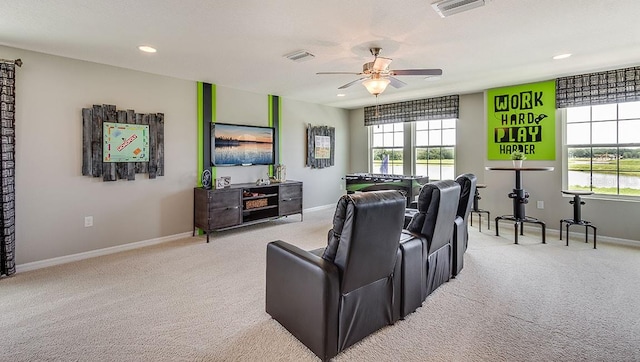 home theater room with light carpet, ceiling fan, and visible vents