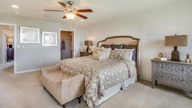 carpeted bedroom with a spacious closet, ceiling fan, and a closet