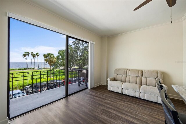 living room with ceiling fan, ornamental molding, a water view, and wood-type flooring