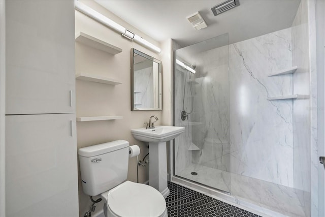 bathroom featuring sink, tile patterned flooring, tiled shower, and toilet