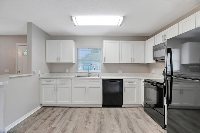 kitchen with sink, light wood-type flooring, black appliances, and white cabinets