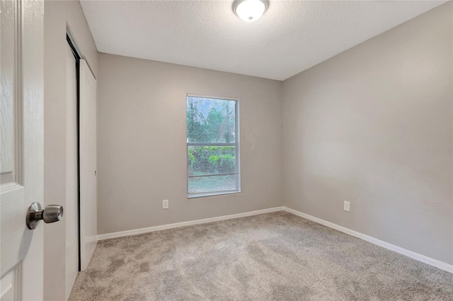 carpeted spare room featuring a textured ceiling