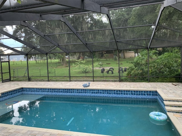 pool with glass enclosure, a yard, and a patio