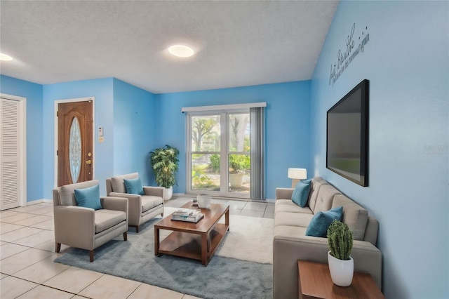 living room with a textured ceiling and light tile patterned flooring