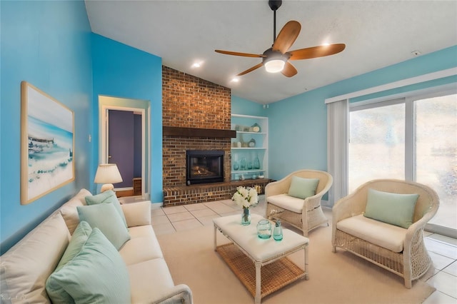 tiled living room with ceiling fan, vaulted ceiling, and a fireplace