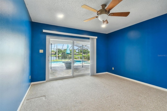 unfurnished room with a textured ceiling, ceiling fan, and carpet