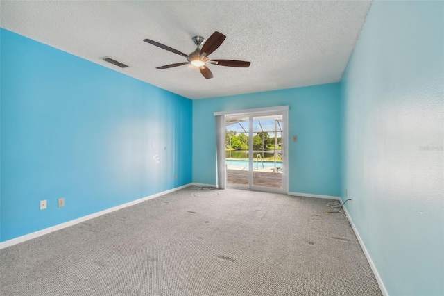 carpeted spare room with ceiling fan and a textured ceiling