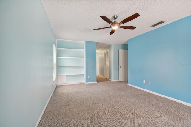 interior space featuring ceiling fan, carpet floors, and a textured ceiling