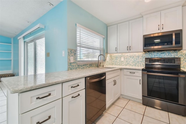 kitchen with appliances with stainless steel finishes, a healthy amount of sunlight, sink, and white cabinets