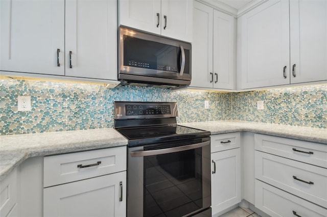 kitchen featuring backsplash, light stone counters, appliances with stainless steel finishes, and white cabinets