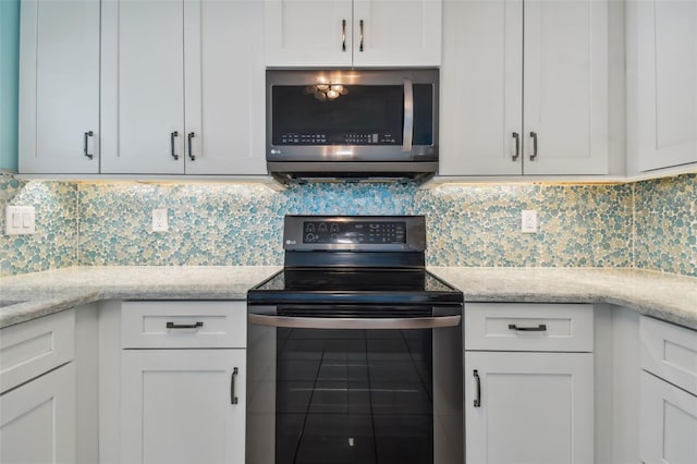 kitchen featuring range with electric cooktop, light stone countertops, white cabinets, and tasteful backsplash