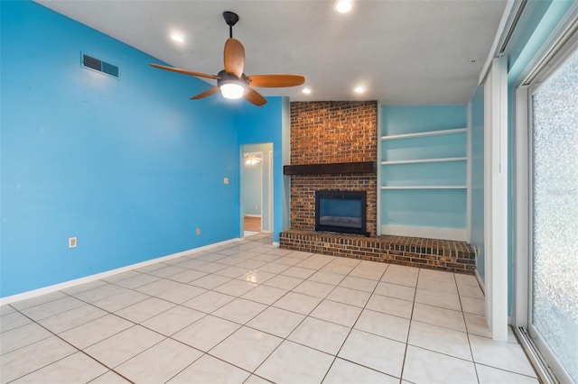 unfurnished living room featuring built in features, ceiling fan, light tile patterned floors, and a fireplace