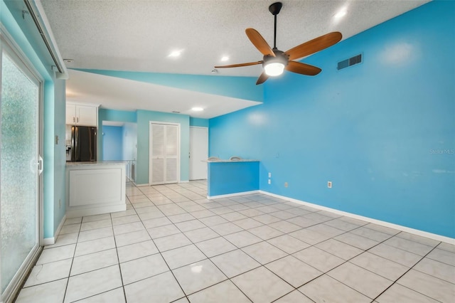 interior space featuring black fridge with ice dispenser, a textured ceiling, ceiling fan, lofted ceiling, and white cabinets