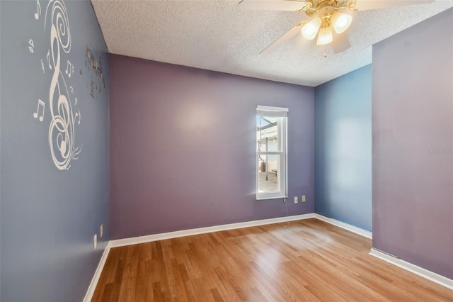 empty room featuring a textured ceiling, ceiling fan, and wood-type flooring