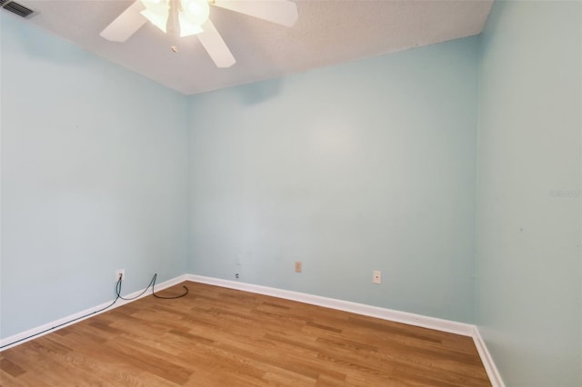 empty room featuring a textured ceiling, wood-type flooring, and ceiling fan