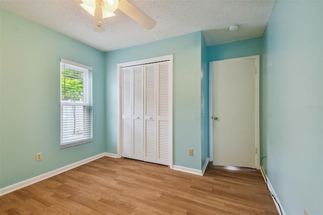 unfurnished bedroom with a closet, a textured ceiling, ceiling fan, and light hardwood / wood-style floors