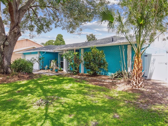 ranch-style home with a front yard and a garage