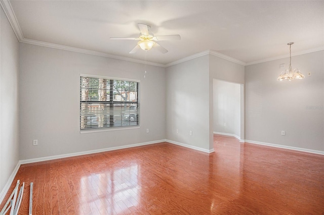 spare room featuring hardwood / wood-style floors, ceiling fan with notable chandelier, and ornamental molding