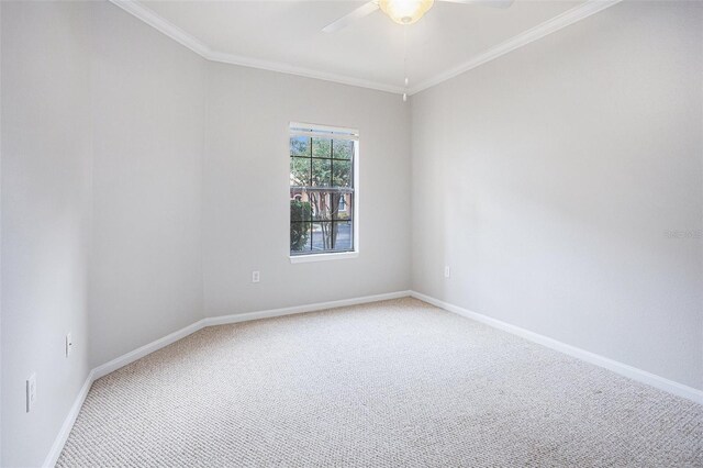 carpeted spare room with ceiling fan and crown molding