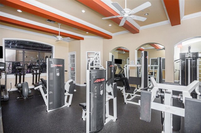 exercise room with ceiling fan, crown molding, and a towering ceiling