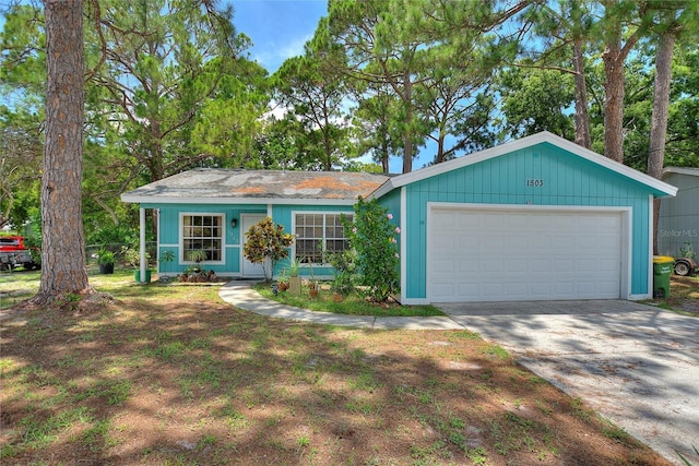 single story home with concrete driveway and an attached garage