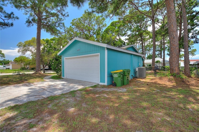 detached garage featuring central AC and fence