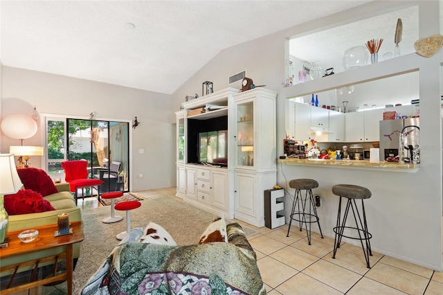 living room featuring lofted ceiling and light tile patterned floors