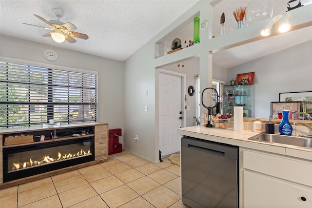 kitchen featuring dishwasher, tile countertops, lofted ceiling, ceiling fan, and light tile patterned flooring