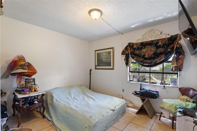 bedroom featuring a textured ceiling and light tile patterned flooring