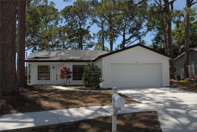 single story home featuring an attached garage, concrete driveway, and a shingled roof