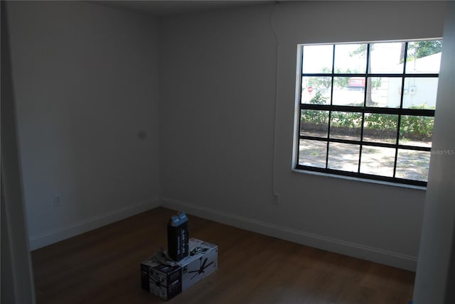 spare room featuring wood finished floors and baseboards
