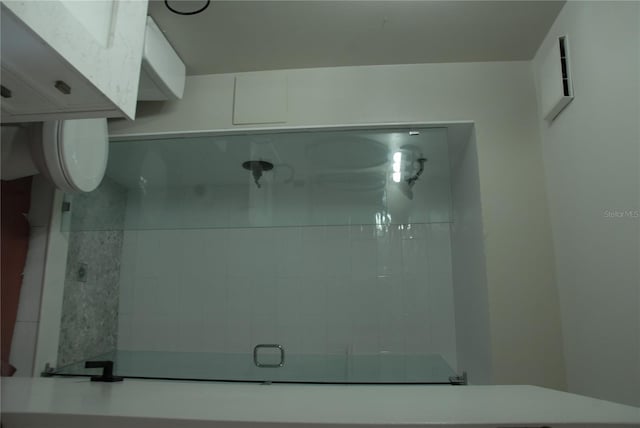 full bathroom featuring a tile shower and toilet