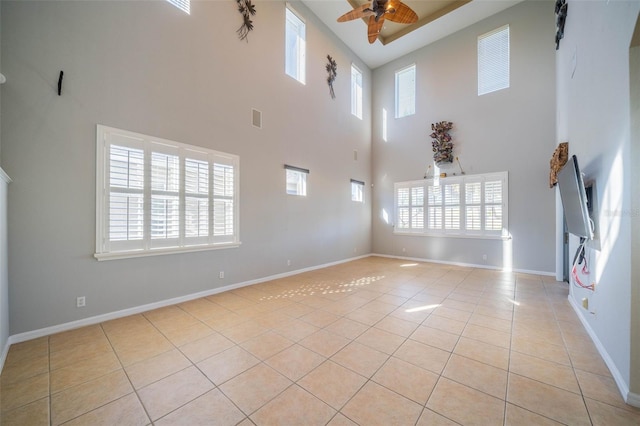 unfurnished living room with light tile patterned floors, ceiling fan, visible vents, and baseboards