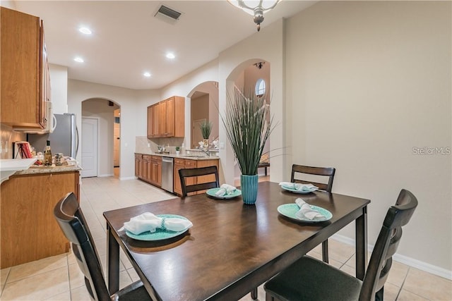 dining room featuring arched walkways, light tile patterned floors, visible vents, and recessed lighting