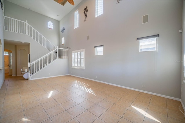 interior space with ceiling fan, a high ceiling, and a wealth of natural light