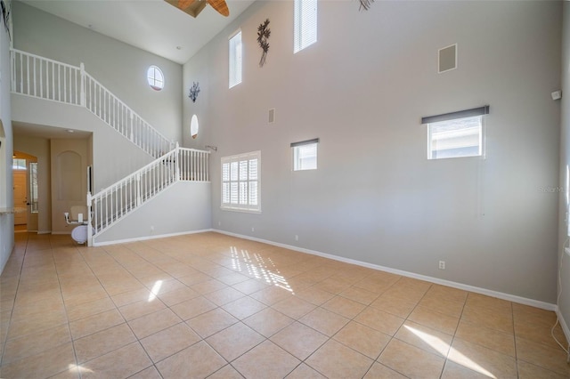 spare room featuring light tile patterned floors, stairs, and baseboards