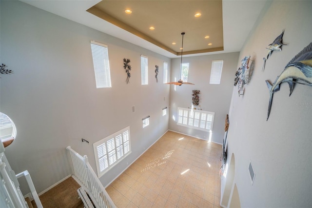 interior space featuring a raised ceiling, ceiling fan, and a baseboard radiator