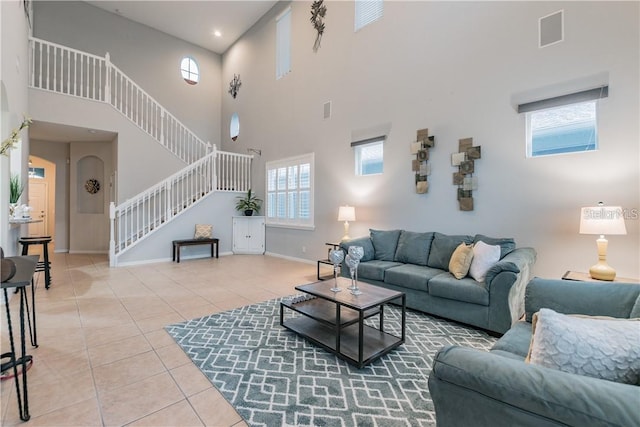 living room featuring tile patterned flooring, baseboards, and stairs