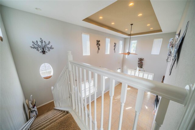 stairway featuring a raised ceiling