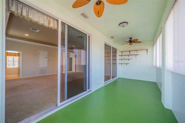 unfurnished sunroom featuring a ceiling fan and visible vents