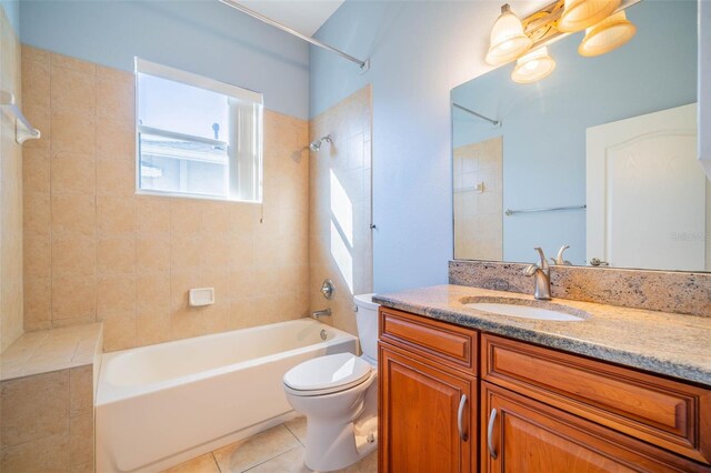 full bathroom featuring tile patterned floors, vanity, tiled shower / bath combo, and toilet