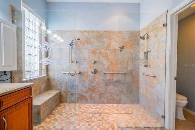 bathroom with tile patterned floors, vanity, a tile shower, and toilet