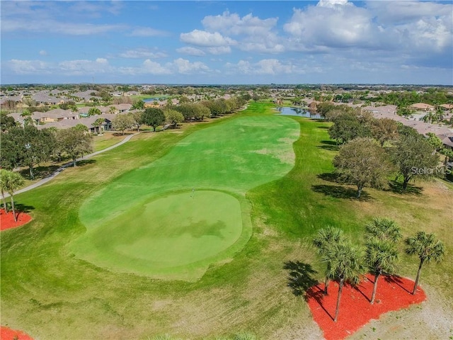 birds eye view of property with view of golf course and a water view
